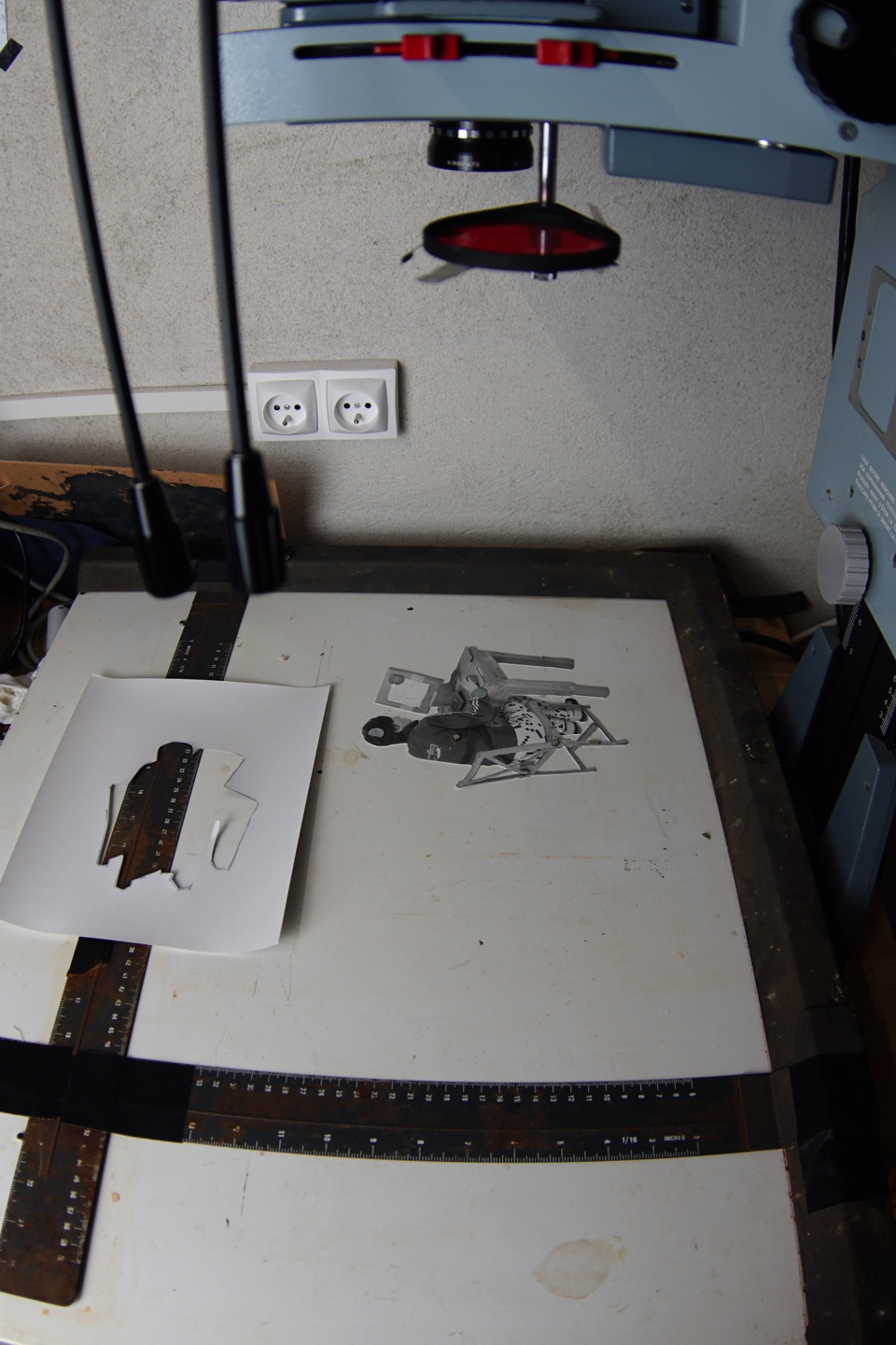 use magnets to hold the masks in place over the paper, the safelight filter on the enlarger to align the next negative with the mask, remove that mask, expose, rinse, repeat, pray.