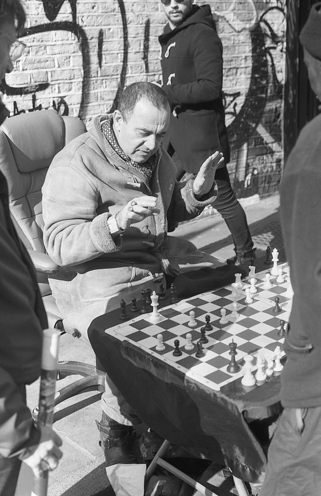 black and white film photo of man playing chess 