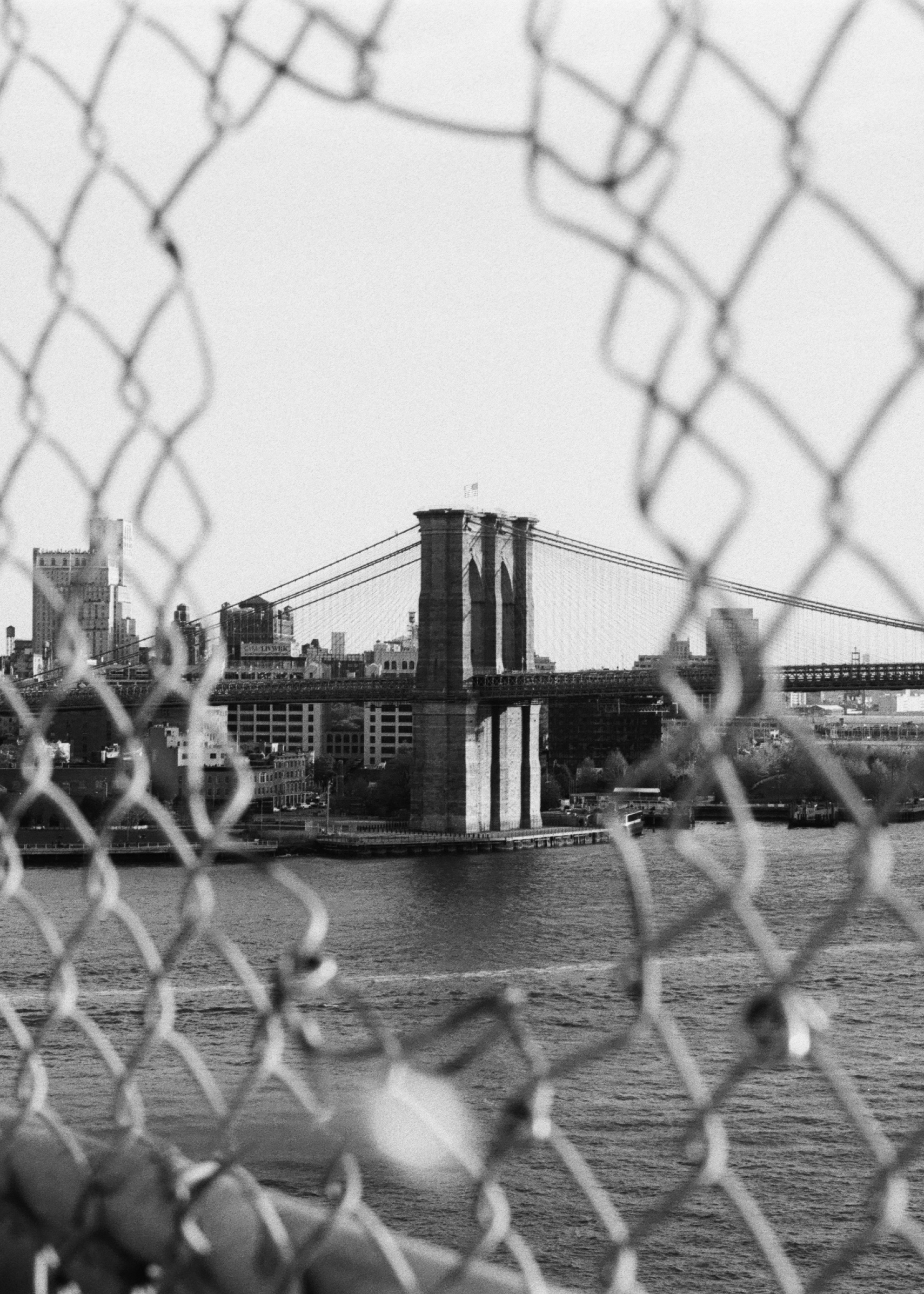 Brooklyn Bridge through the wire on HP5 black and white film by Louis Kassam