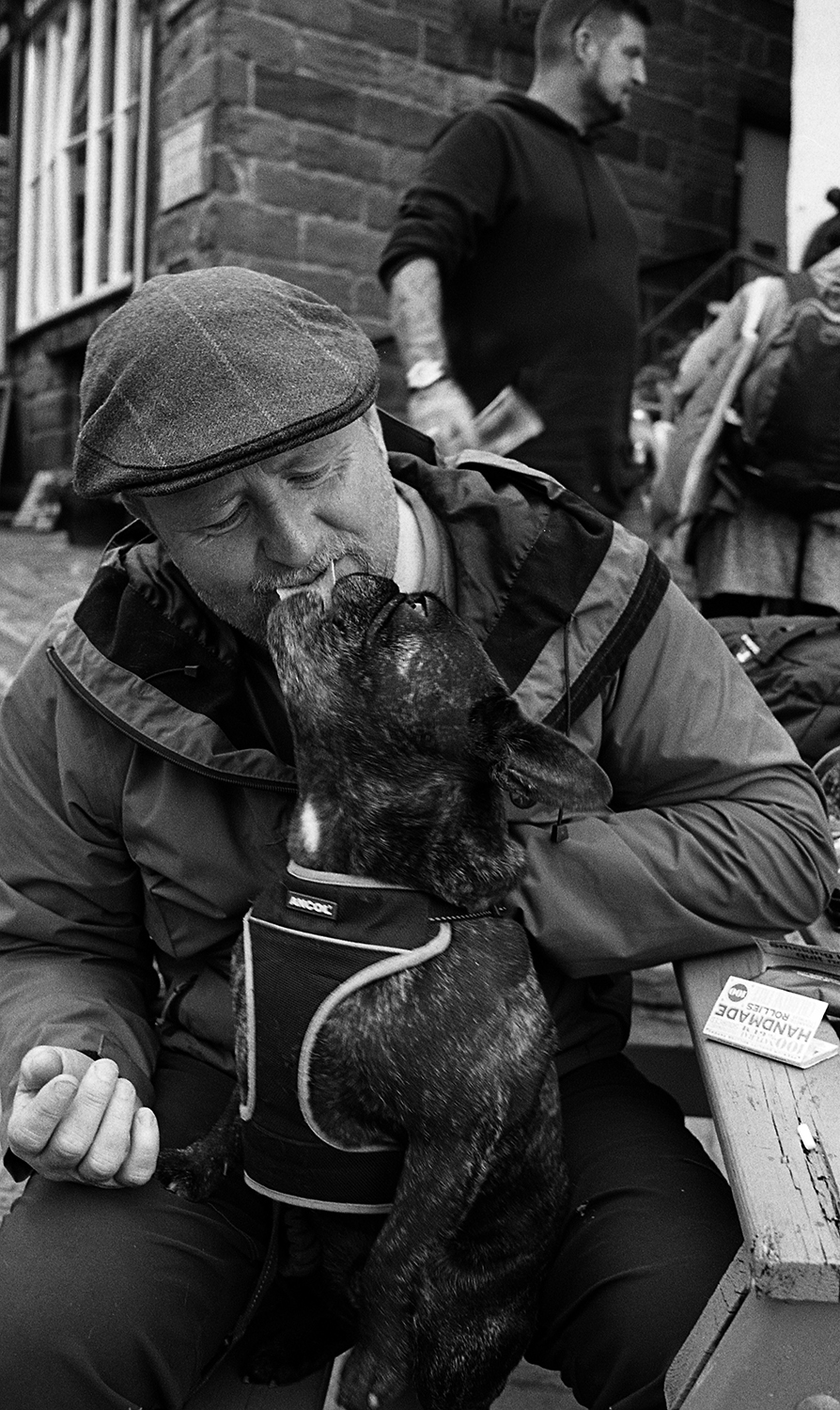 Man feeding doy in Robinhuds bay shot on ILFORD black and white film by Keith Moss