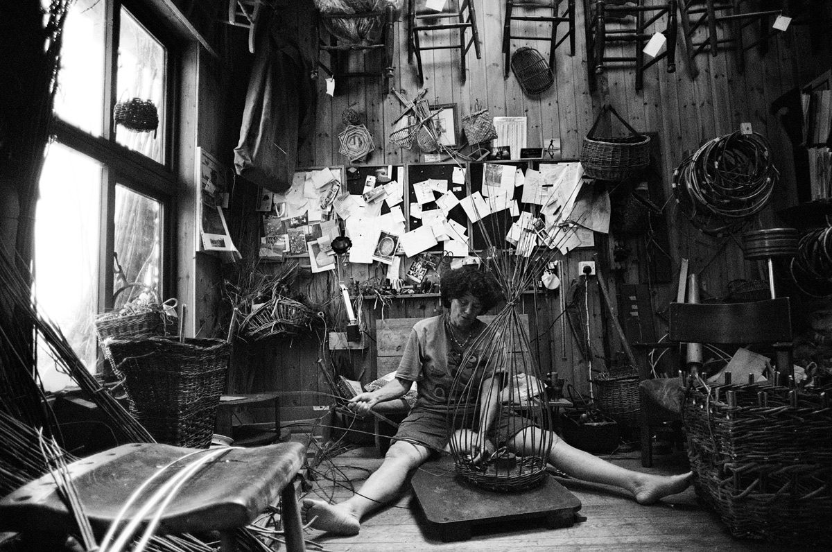 Linda Lemieux, a basket maker, cutting rushes in Somerset from a coracle she built herself on 09 June 2020 and weaving a basket in her workshop in Devon on 31 May 2020 Using Olympus OM-40 Program with XP2 Super and Zuiko 21 mm/f3.5 lens.