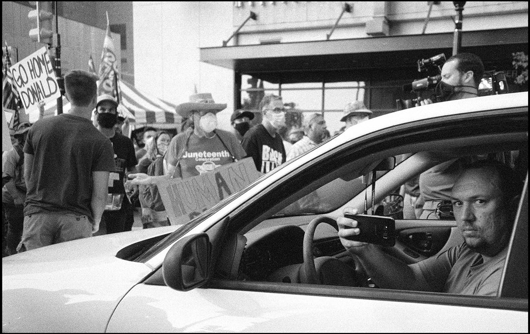 A man documents the chaos out side of Donald Trump’s rally. Tulsa, OK. Ilford Delta 400.