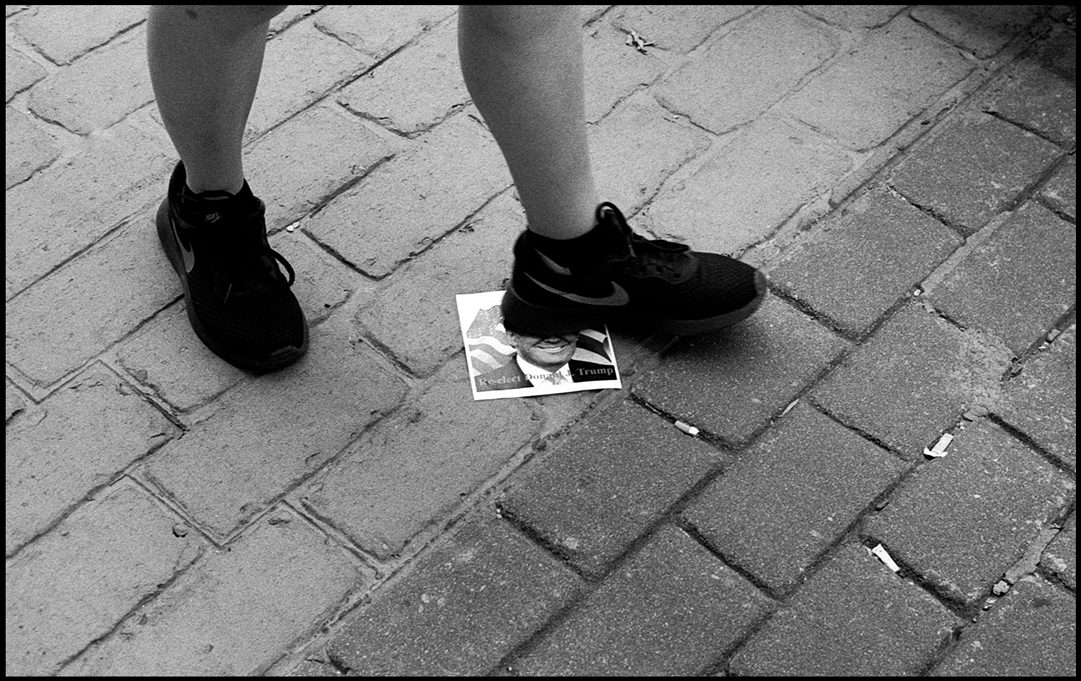 Trump supporter steps on a leaflet. Tulsa, OK. Ilford Delta 400.