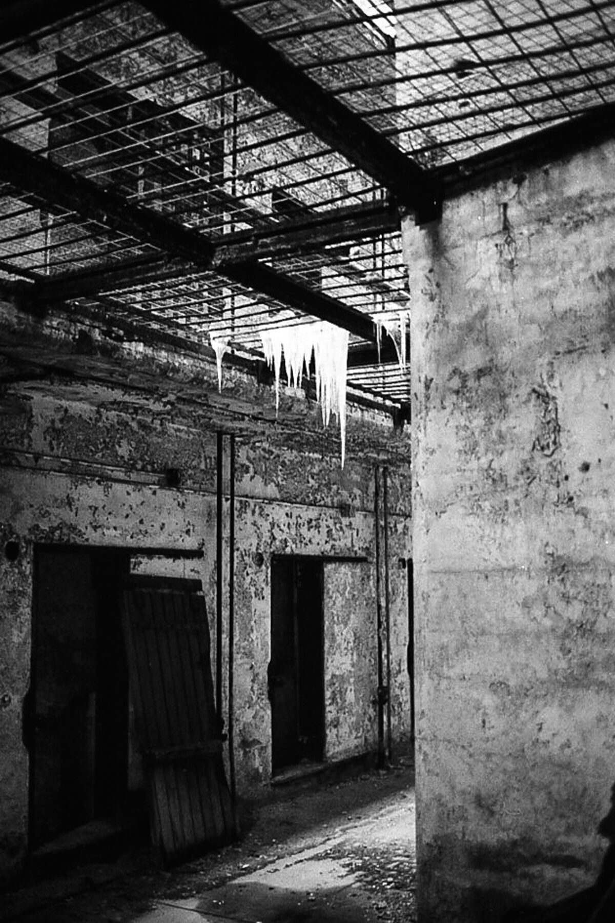Only a portion of the prison has been made safe for visitors. Photographing through rusty bars and gates is possible to capture the most derelict areas. A break in the skylight made these icicles and the light on them caught my eye.