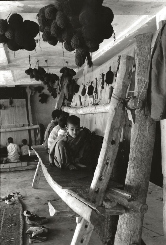 Black and white photograph of children weavers sat down