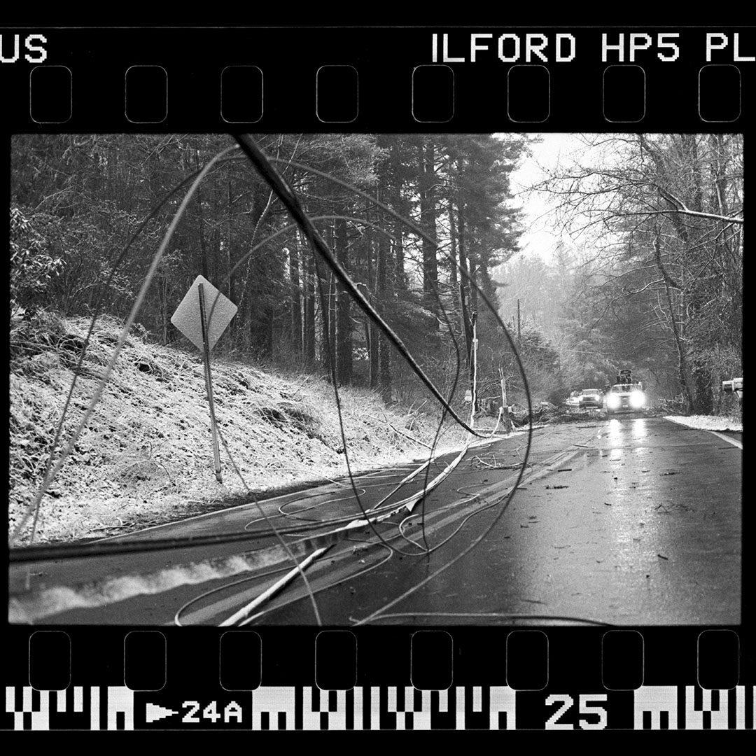 Black and white negs of men working in the snow