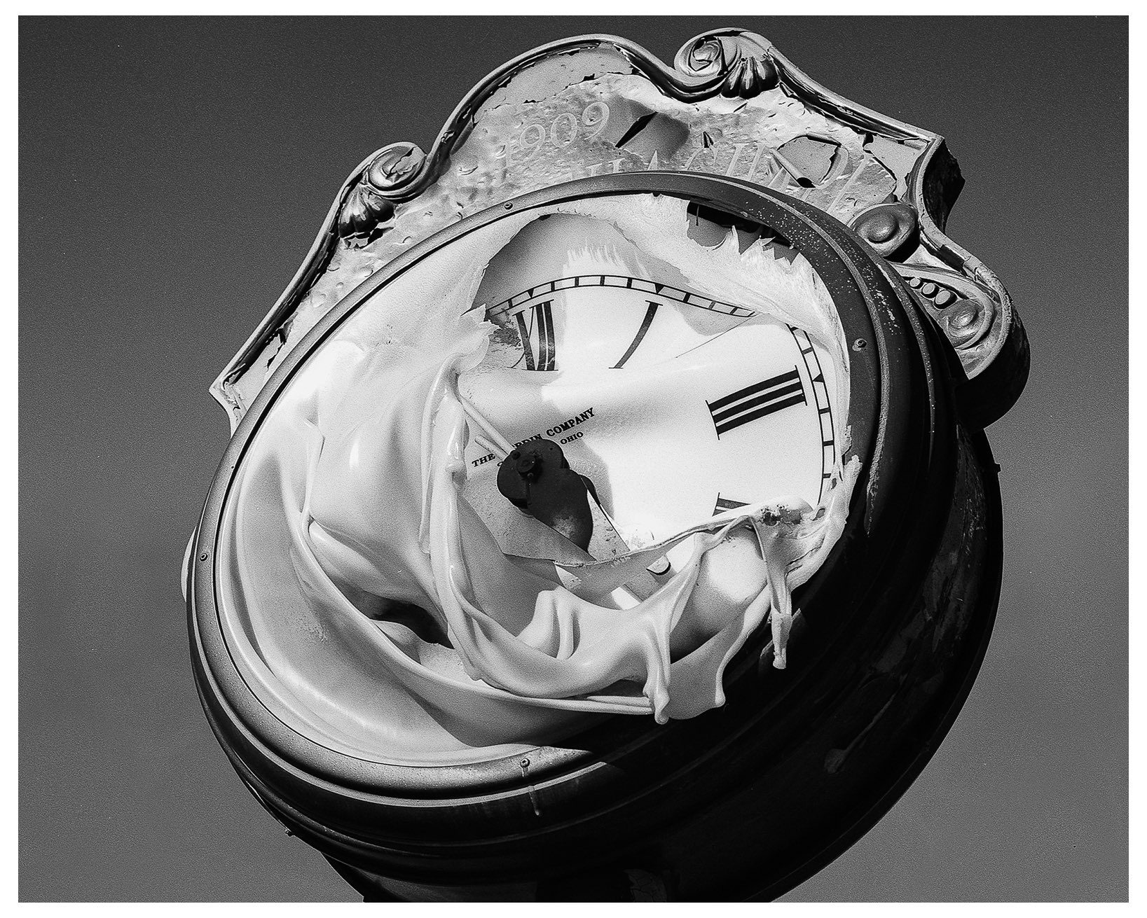 Black and white image of a clock statue among the sky