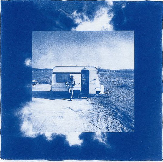 cyanotype print of a caravan with a man stood in front