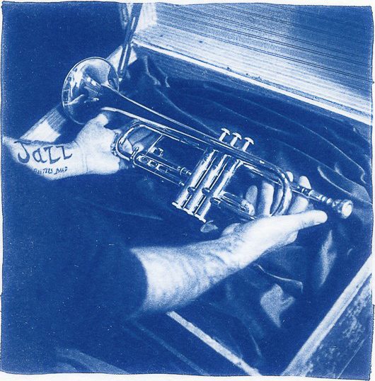 Blue cyanotype print of a man holding an instrument