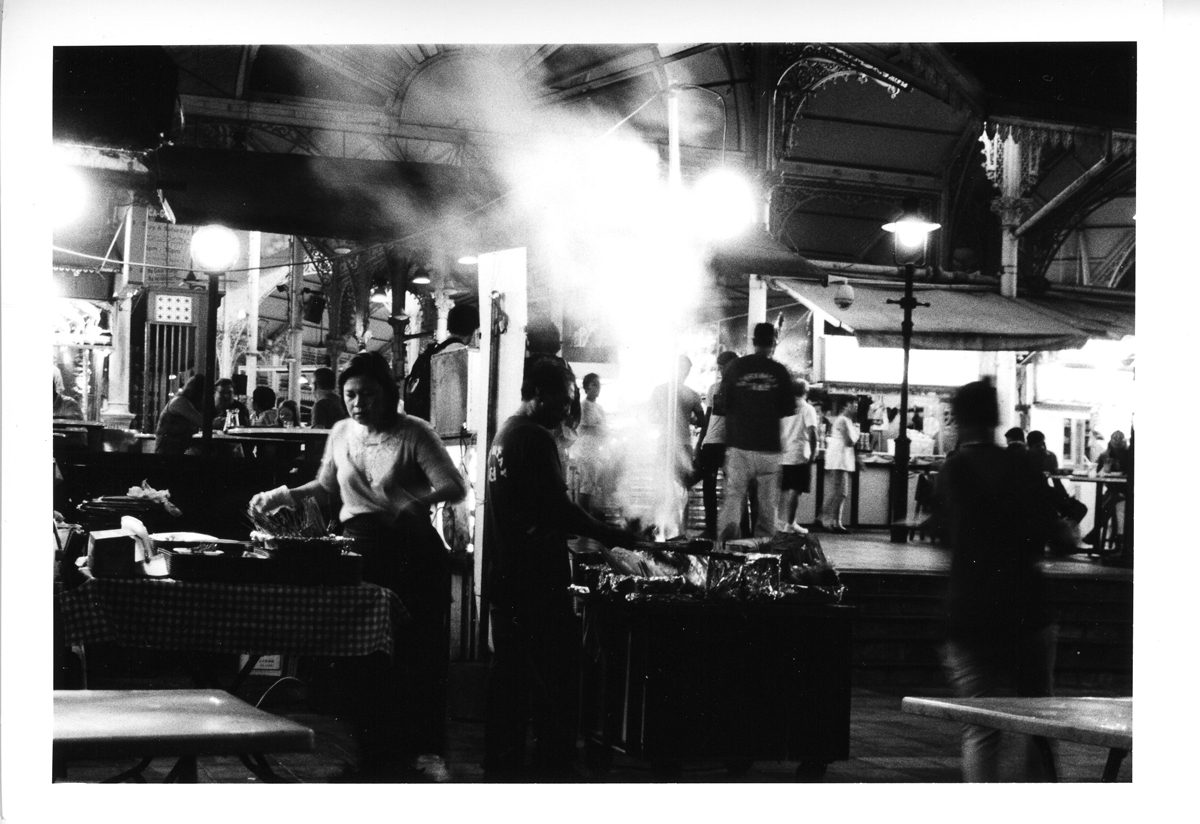 High contrast black and white image of a market with a lot of smoke