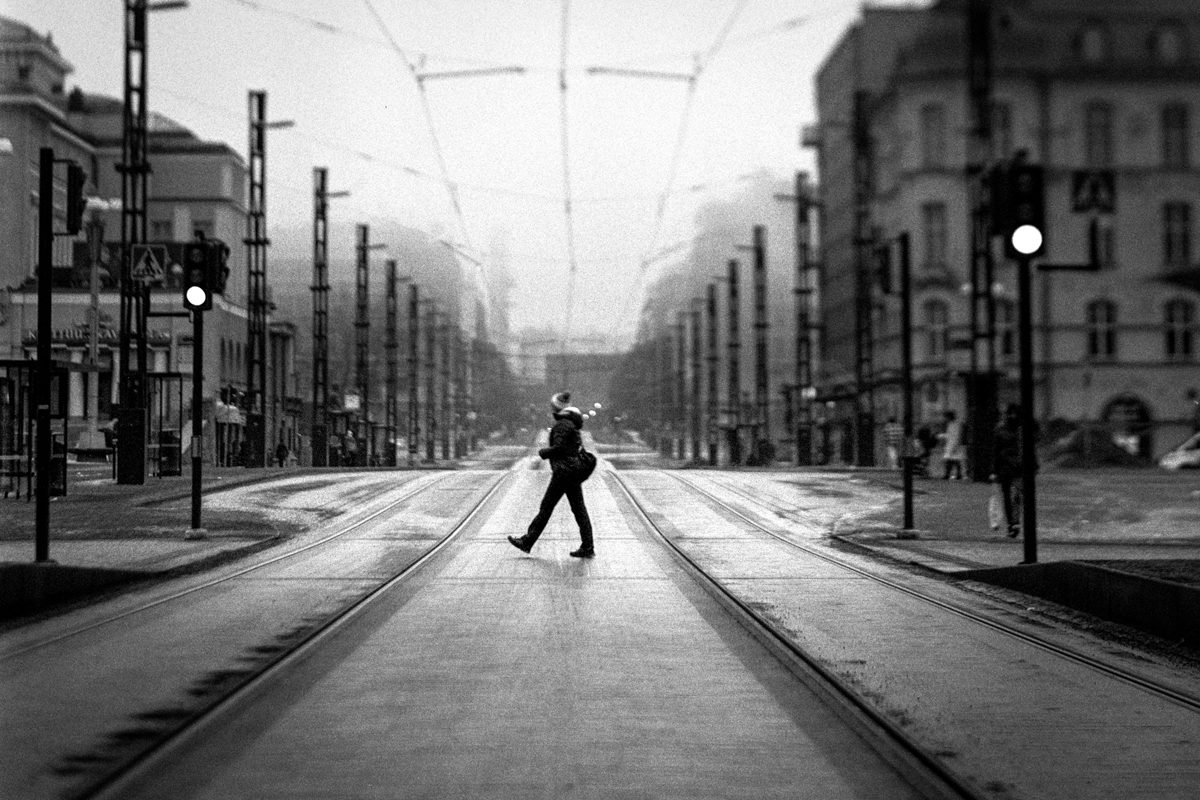 Black and white street photograph of a person walking