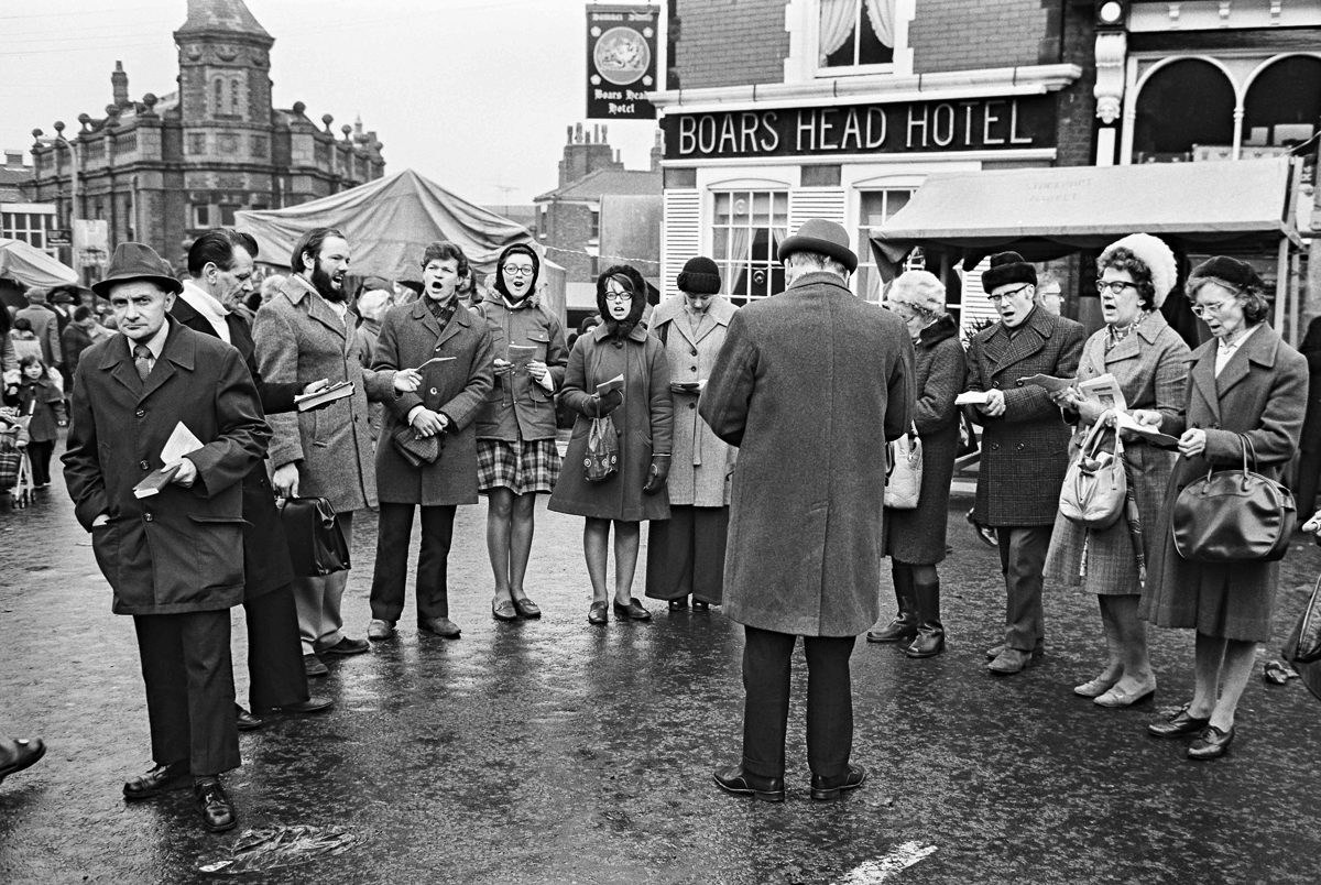 Blakc and white image of singers lined up in a square