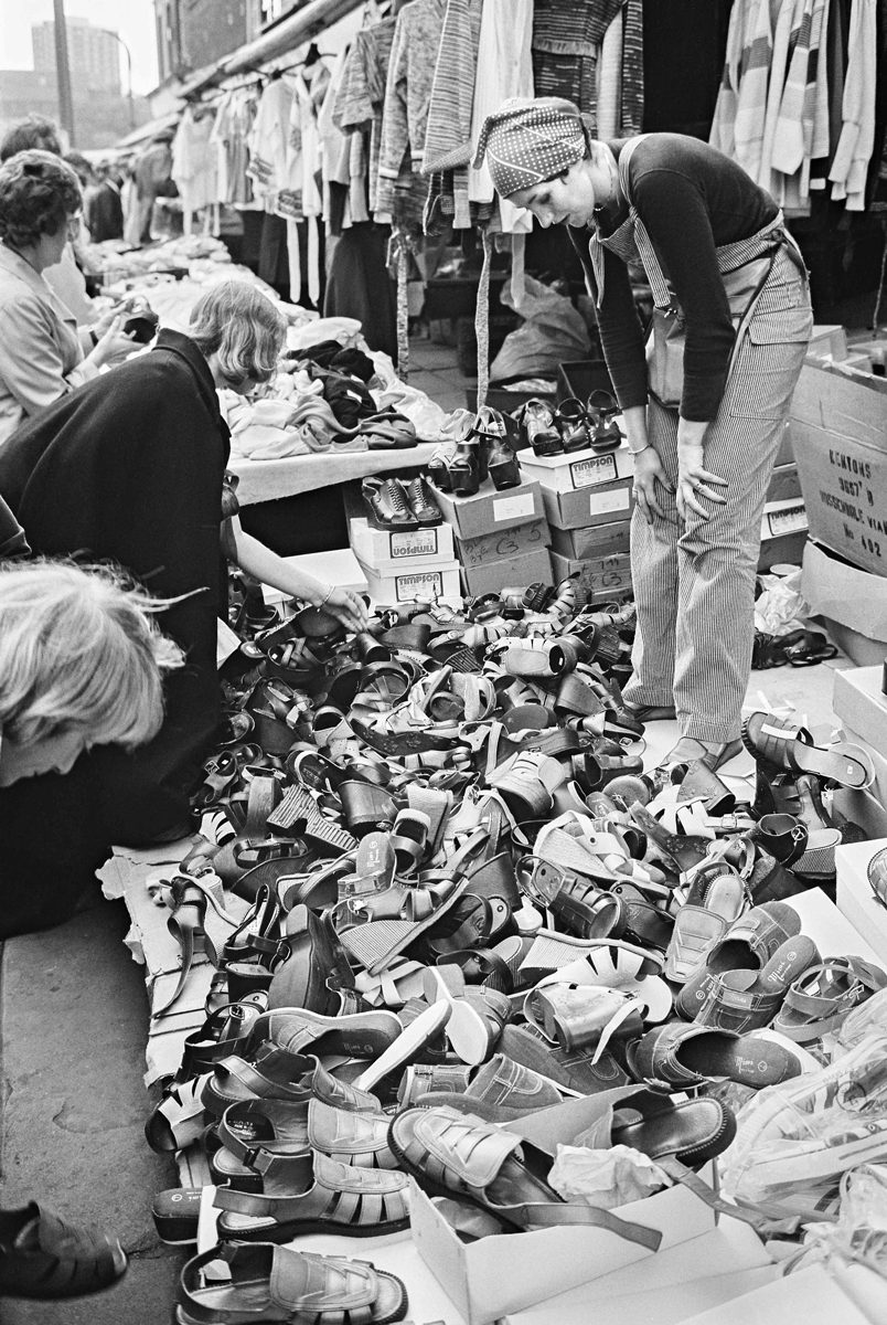 Black and photo of many shoes at a market being sold