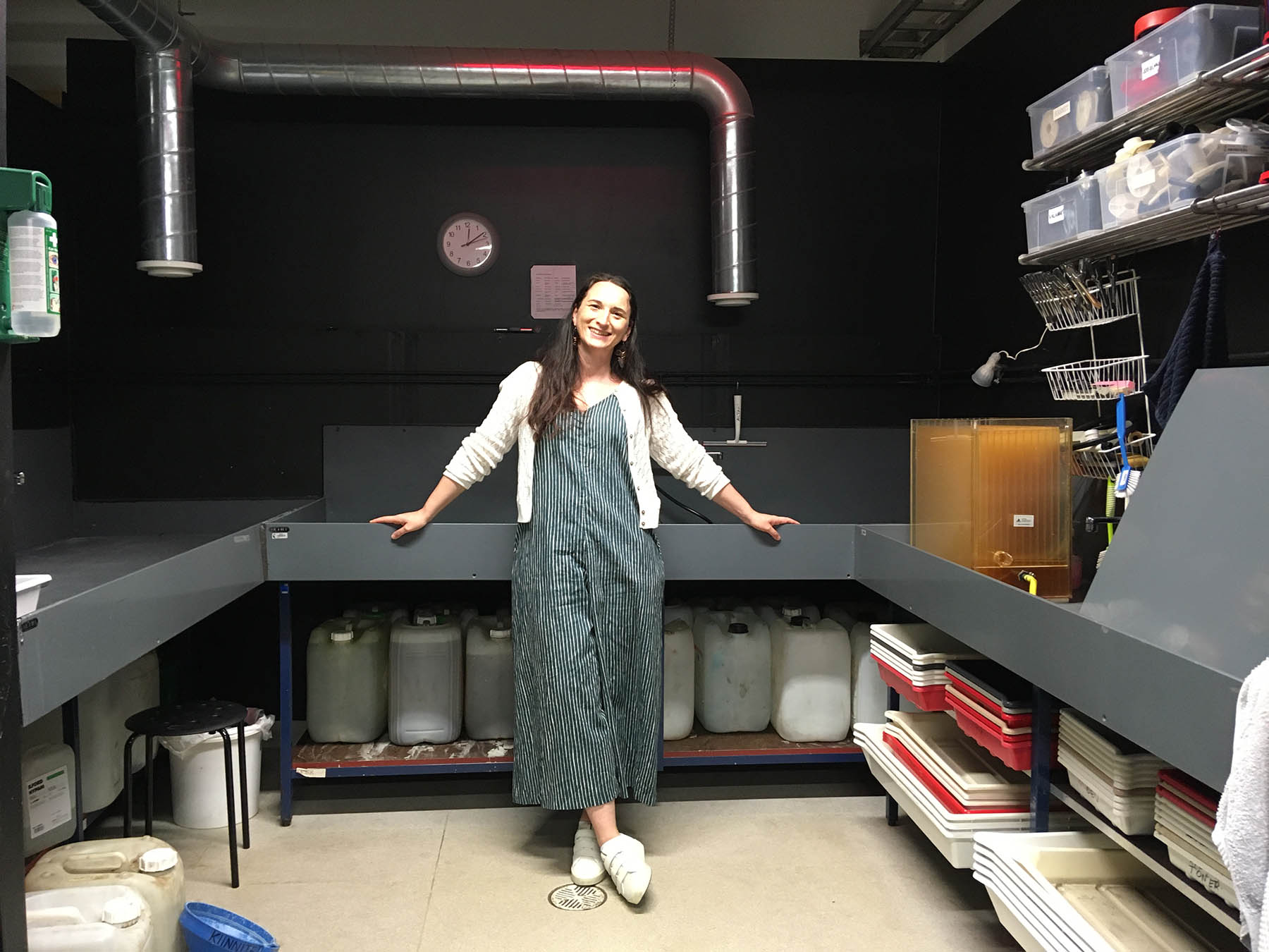 Colour image of the artists stood up in a darkroom