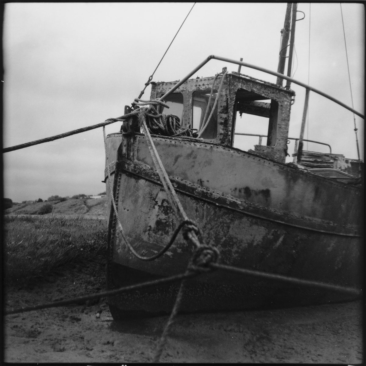 Black and white darkroom print of a boat on land
