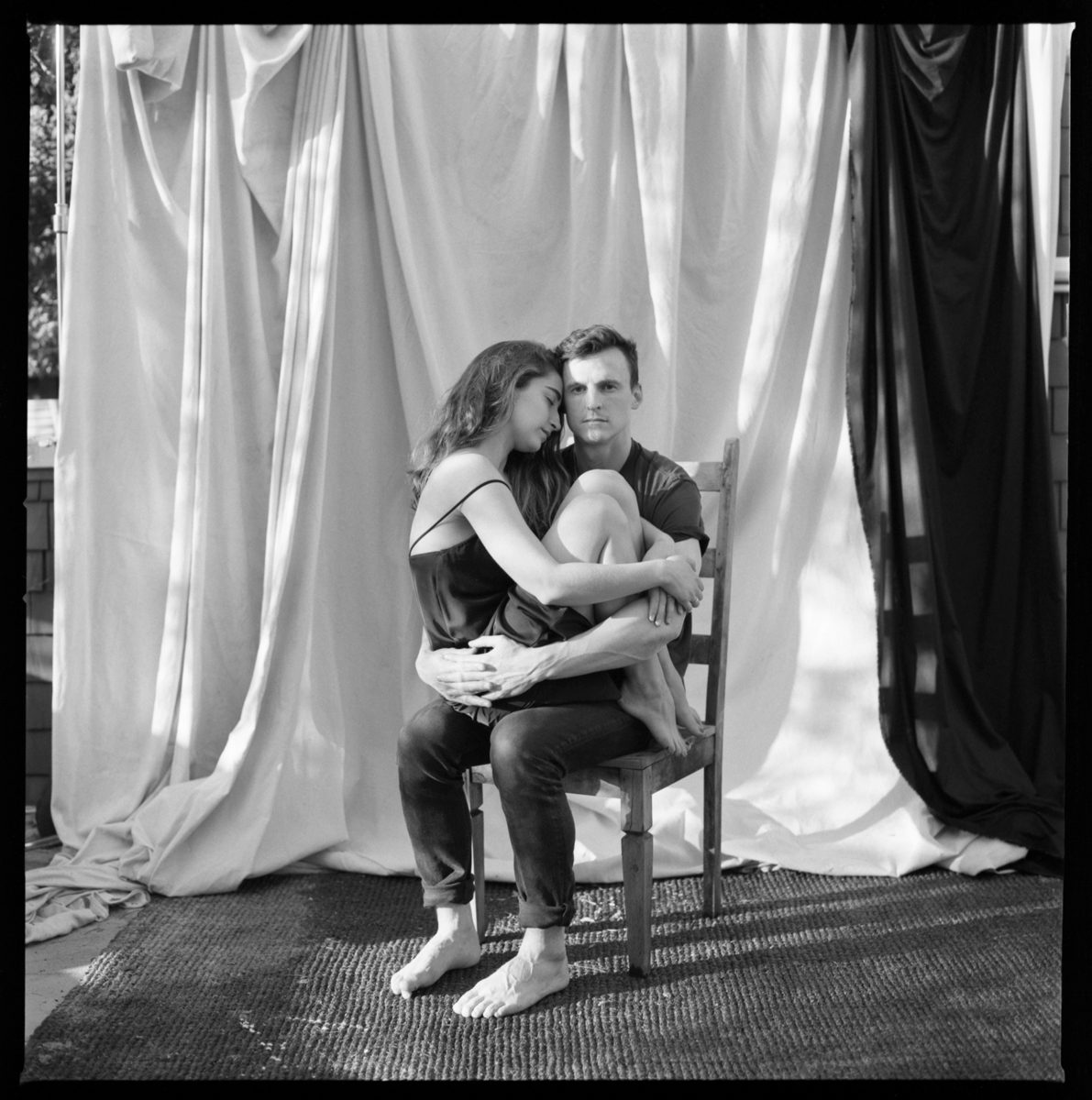 Man and woman sat on a chair together on one another