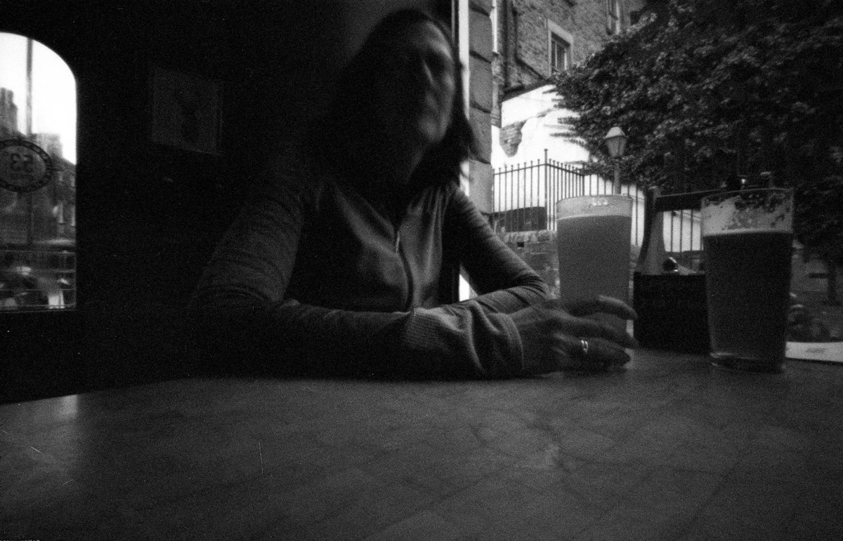 Person sat having a drink, slightly blurred