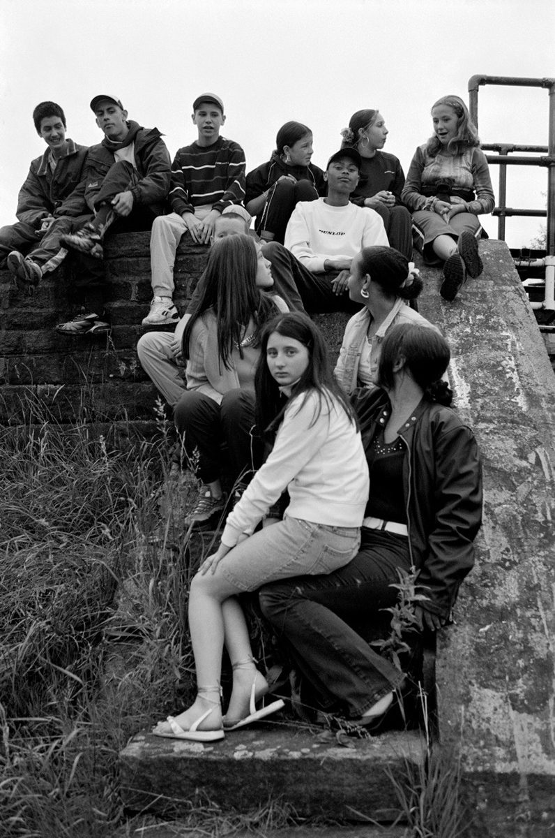 Young teenagers in a group sat on a hill