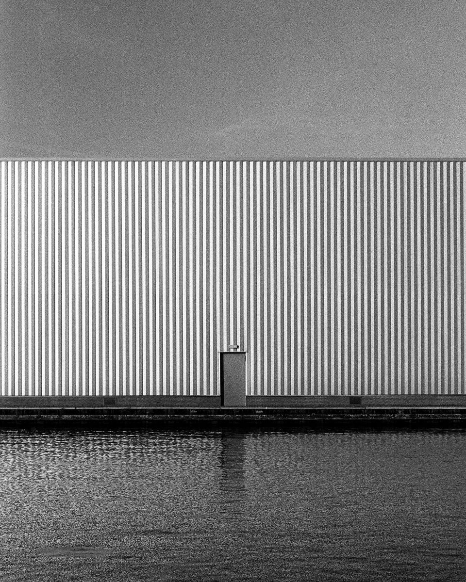 Black and white photo of a building with water 