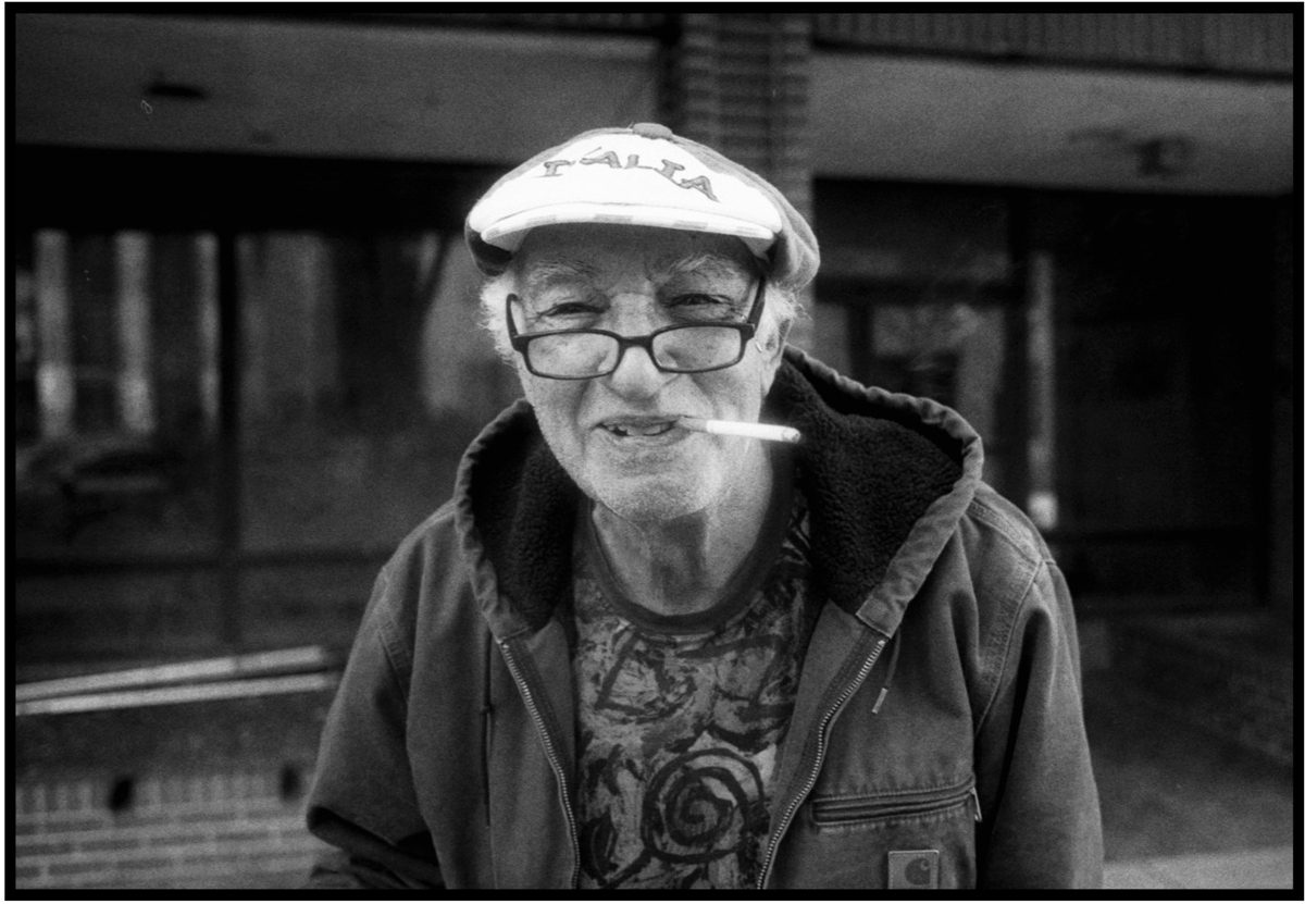 Old man smiling with a cigarette in his mouth