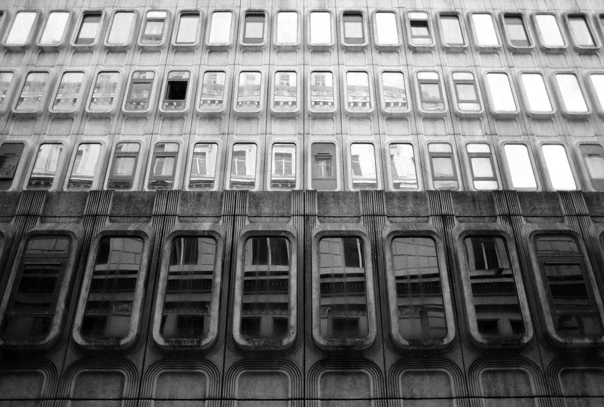 Black and white photo of a large building with a lot of windows