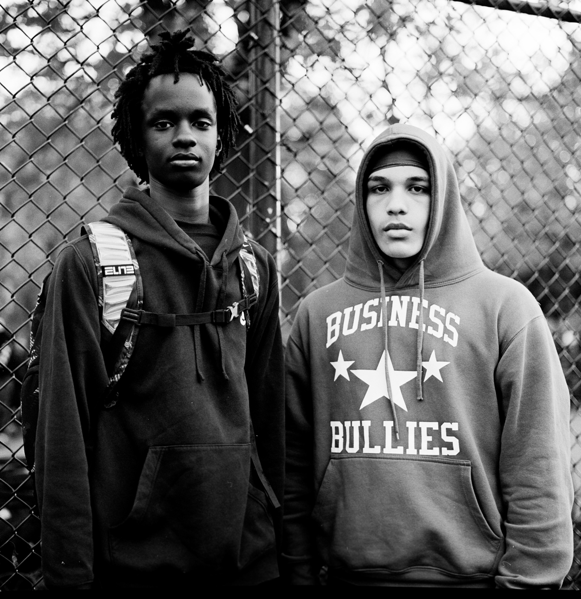 Two boys in front of the camera wearing hoodies