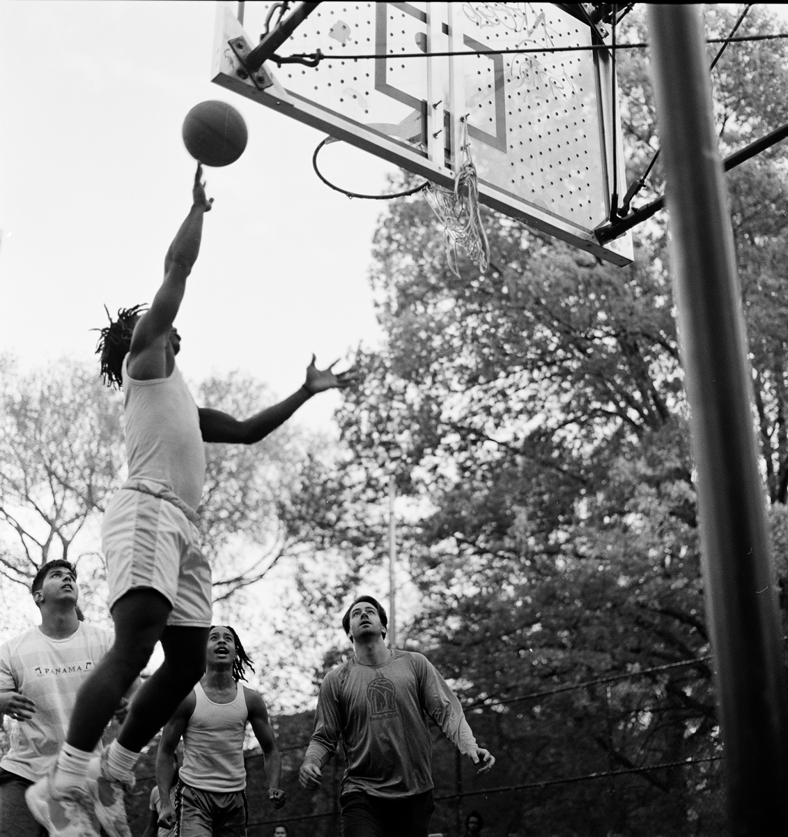 A man jumping up to score in basketball