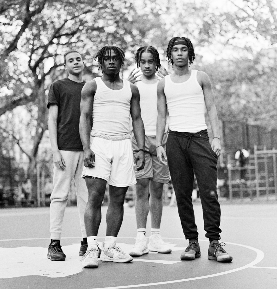 Four men stood in front of a camera on a basketball court