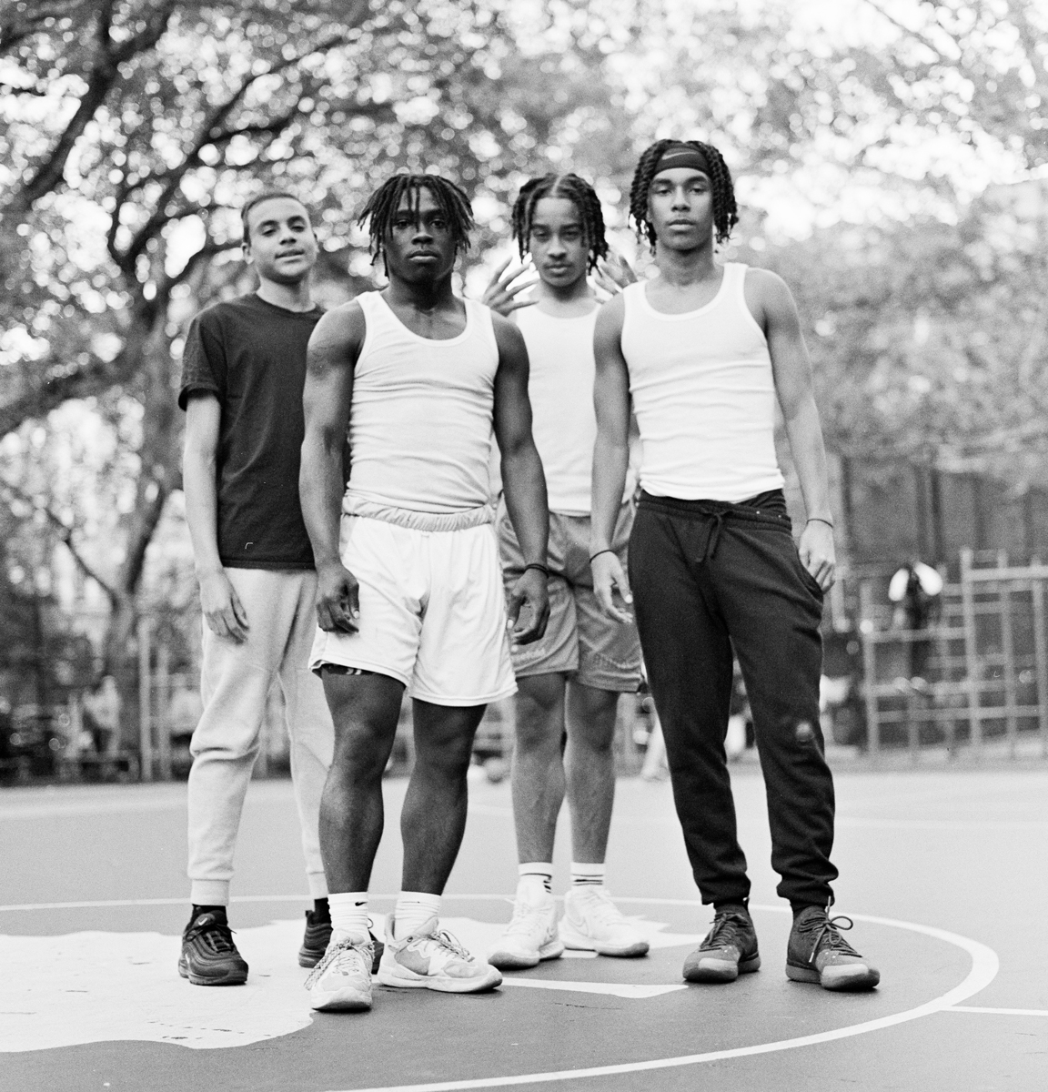 Four men stood in front of a camera on a basketball court