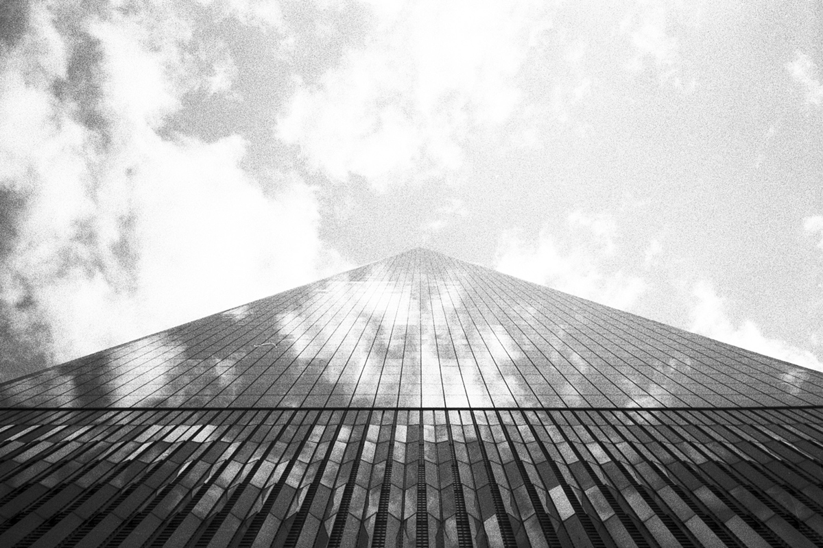 Picture looking up at a glass building in the sky