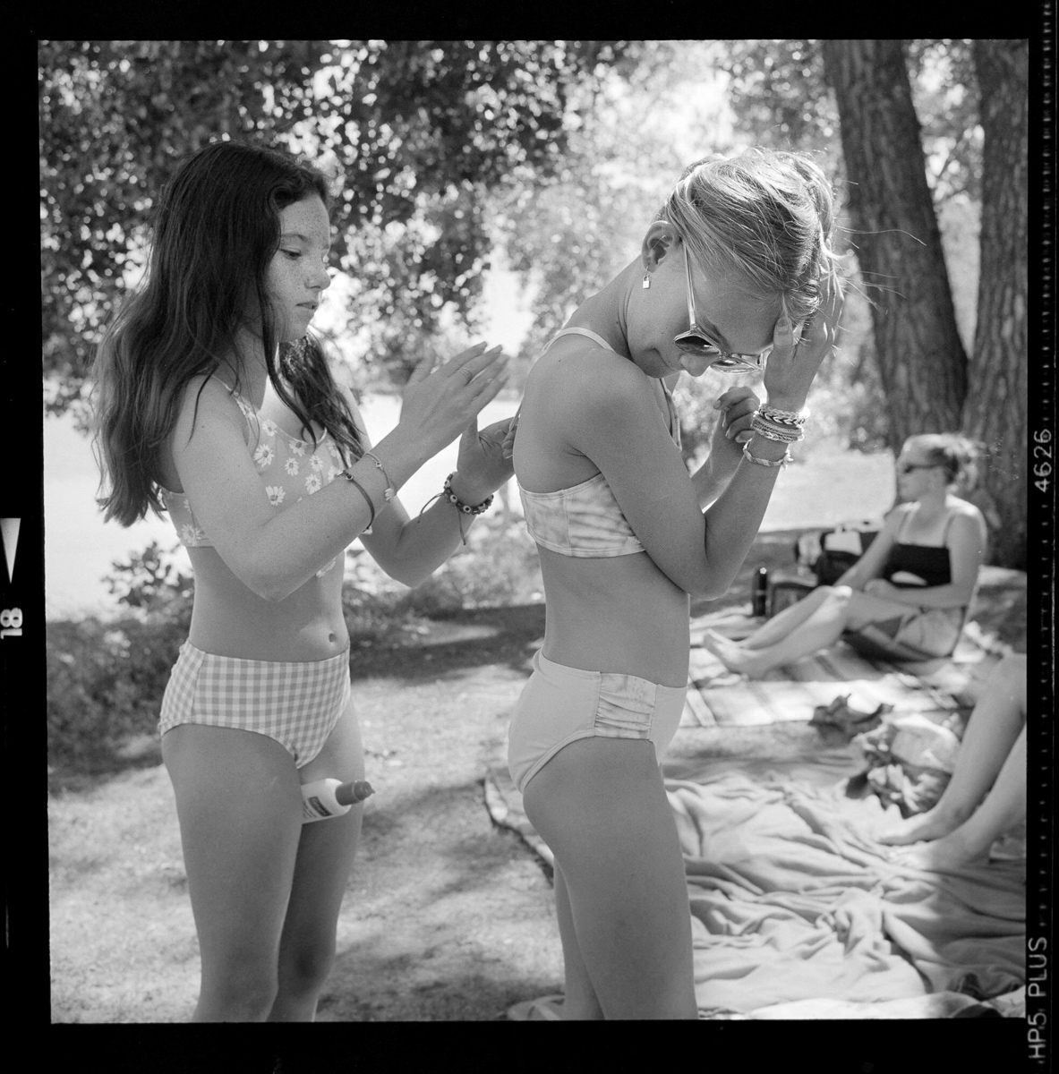 Two young girls applying sun cream on a beach