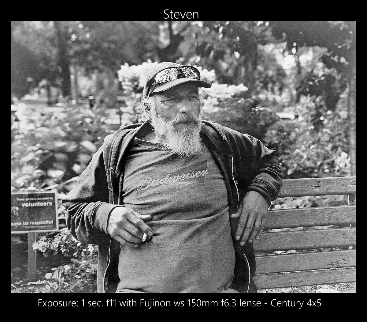 Man sat on a bench holding a cigarette