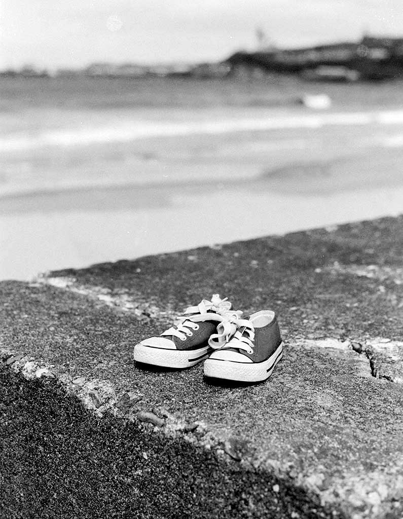 Small pair of baby converse trainers on the beach