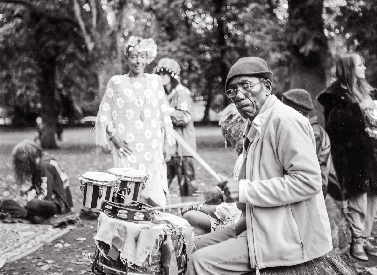 Elderly man playing the drums in a park