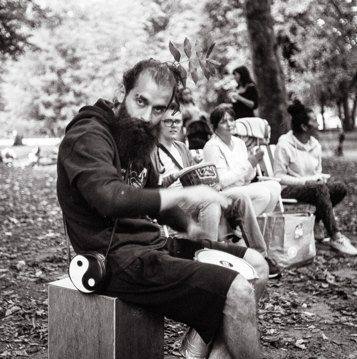 man with a beard playing drum while sat down