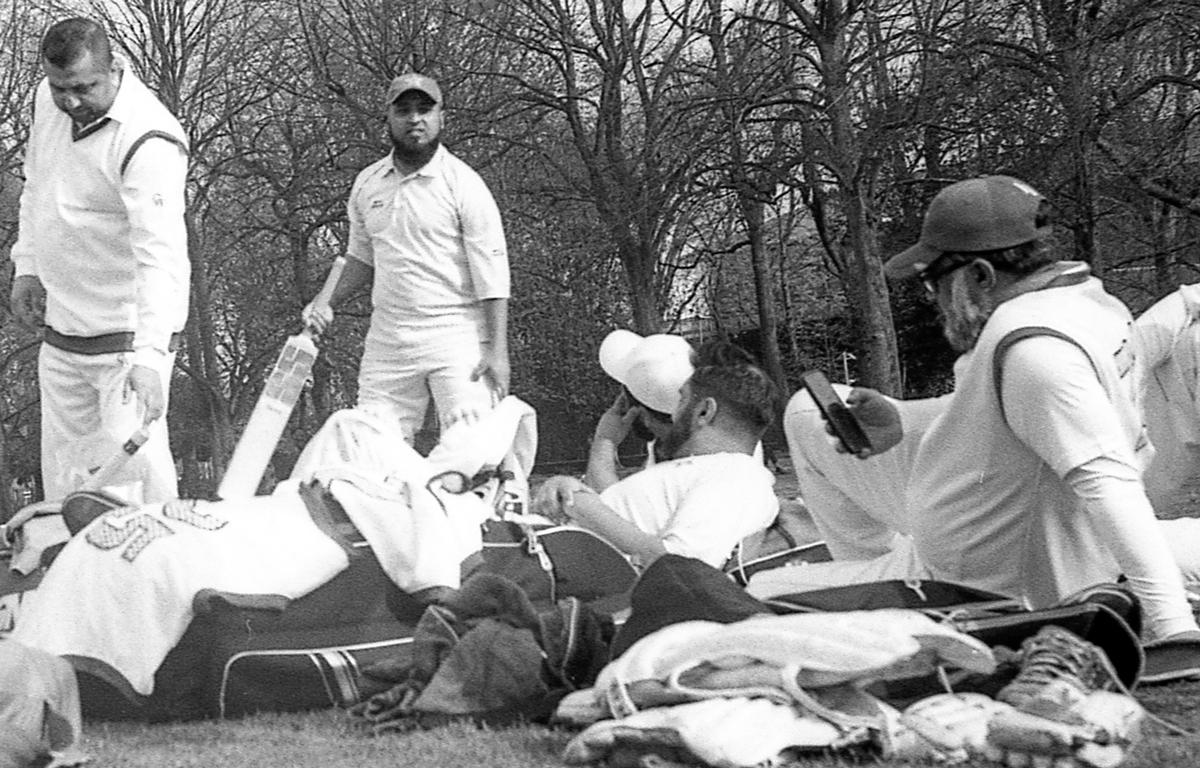 Cricket players laying down on grass