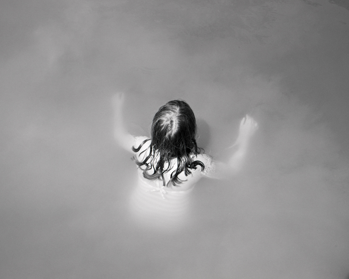 Young girl swimming in misty water