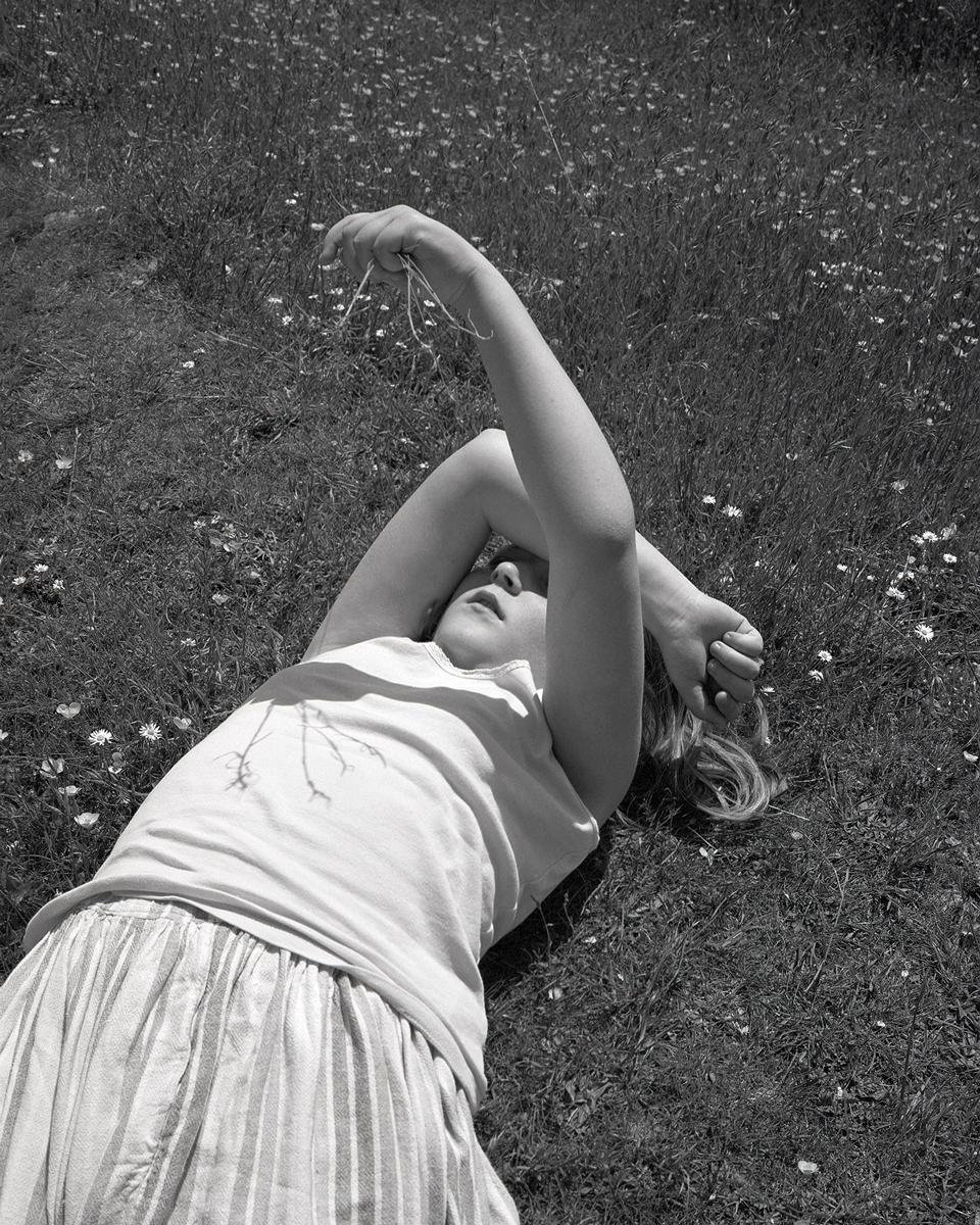 A young girl lay down on the grass 