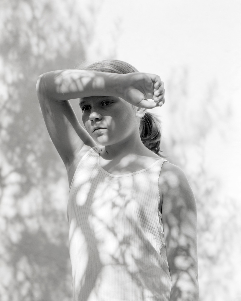 Young girl with her hand up in front of her face 