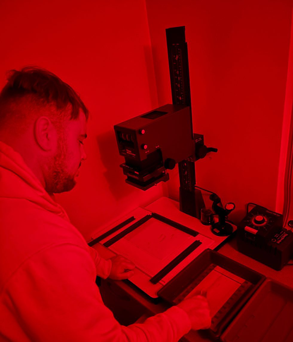 Red shot of a guy printing in the darkroom