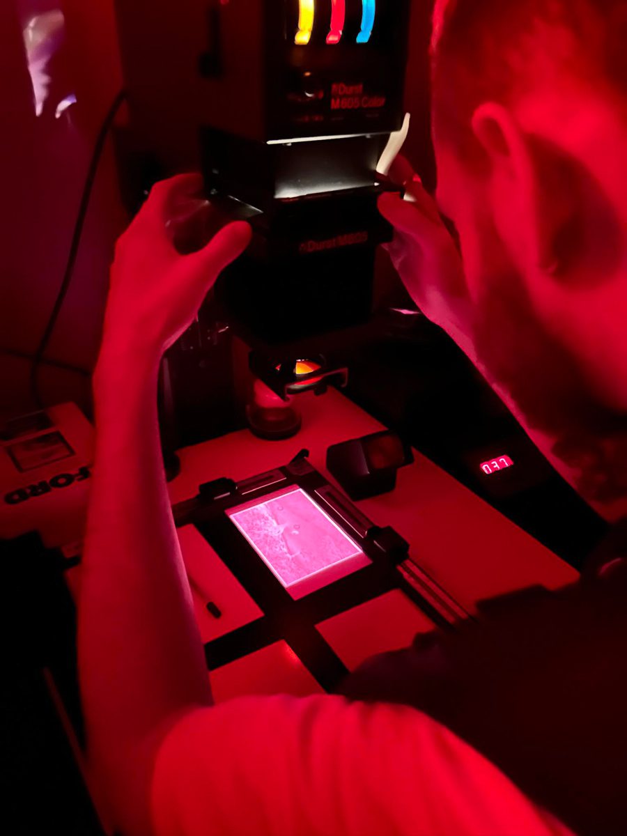 Red shot of a guy printing in the darkroom