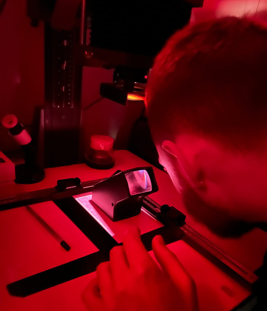 Red shot of a guy printing in the darkroom
