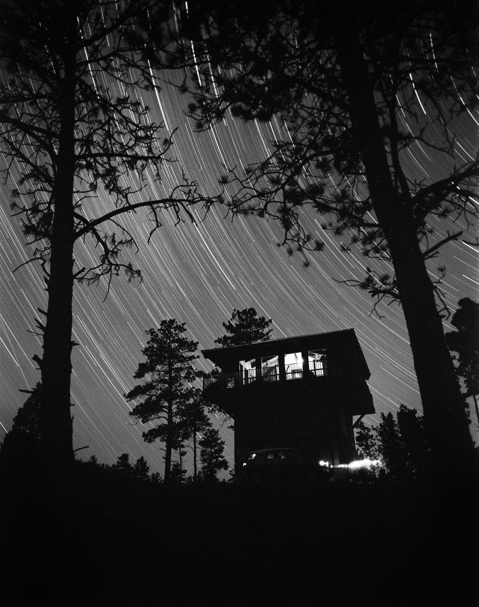 Black and white long exposure star shot with a black house at night