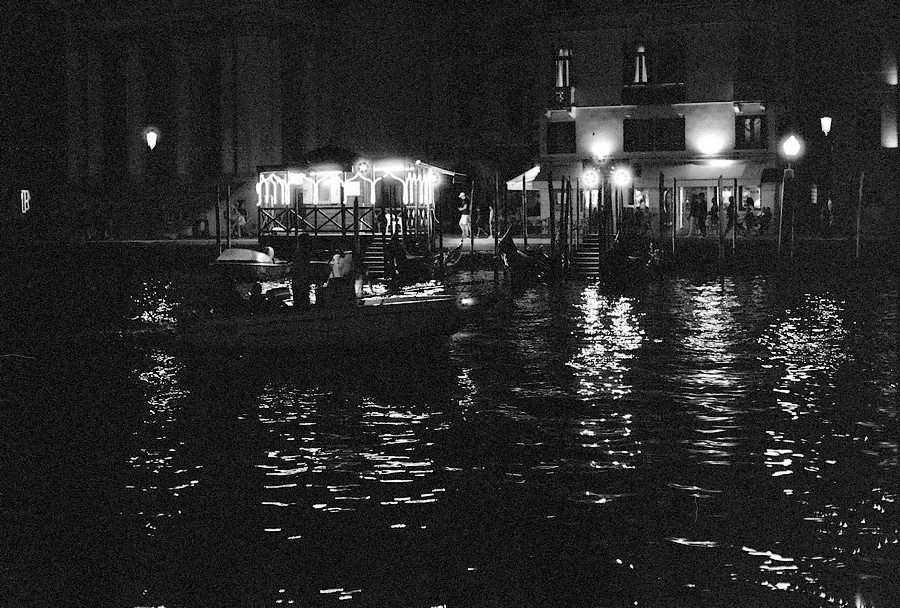 Julian Tanase. Black and white night time image in Venice of a boat.
