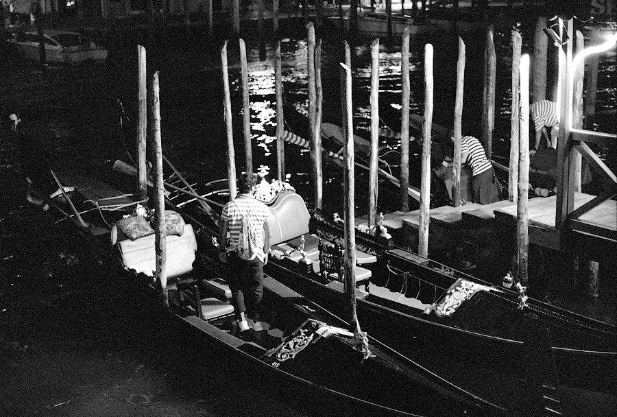 Julian Tanase. Black and white night time shot of boats in Venice