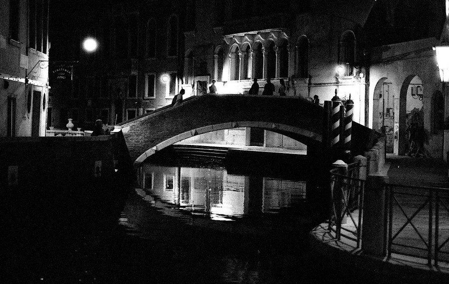Julian Tanase. Black and white night time shot of a bridge in Venice.,