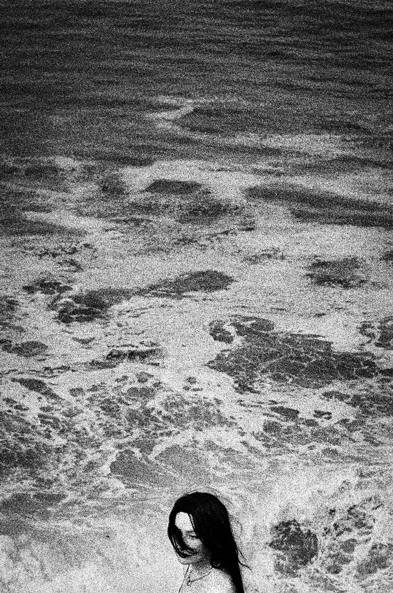 Black and white image of a womans head against the sea