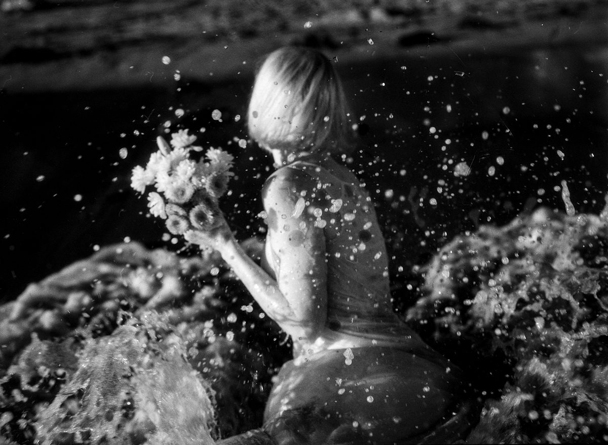 Black and white shot of a person splashing in water