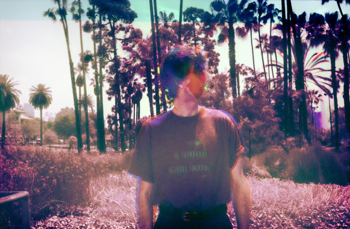 Colour portrait of a man with palm trees behind