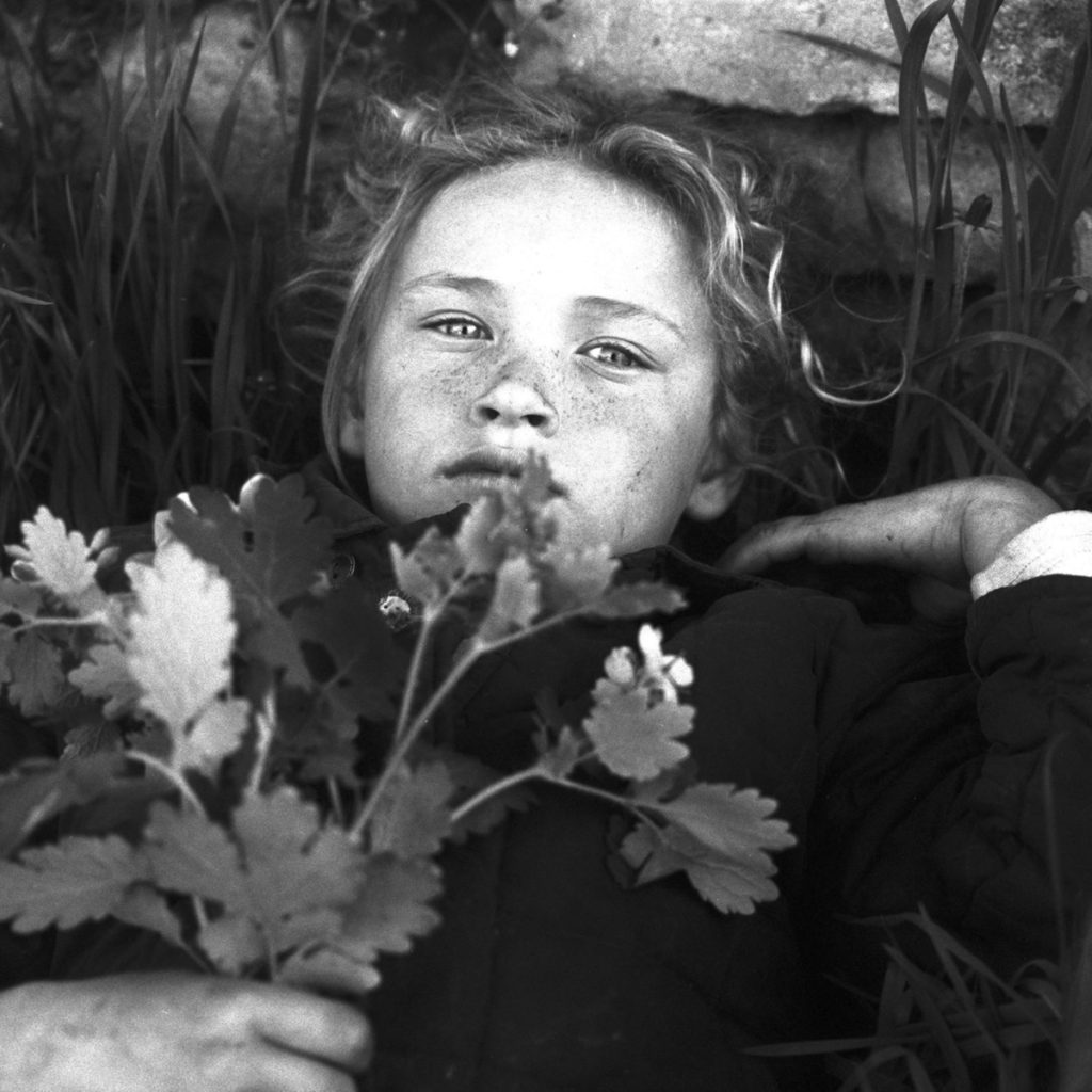 Black and white shot of a child with flowers